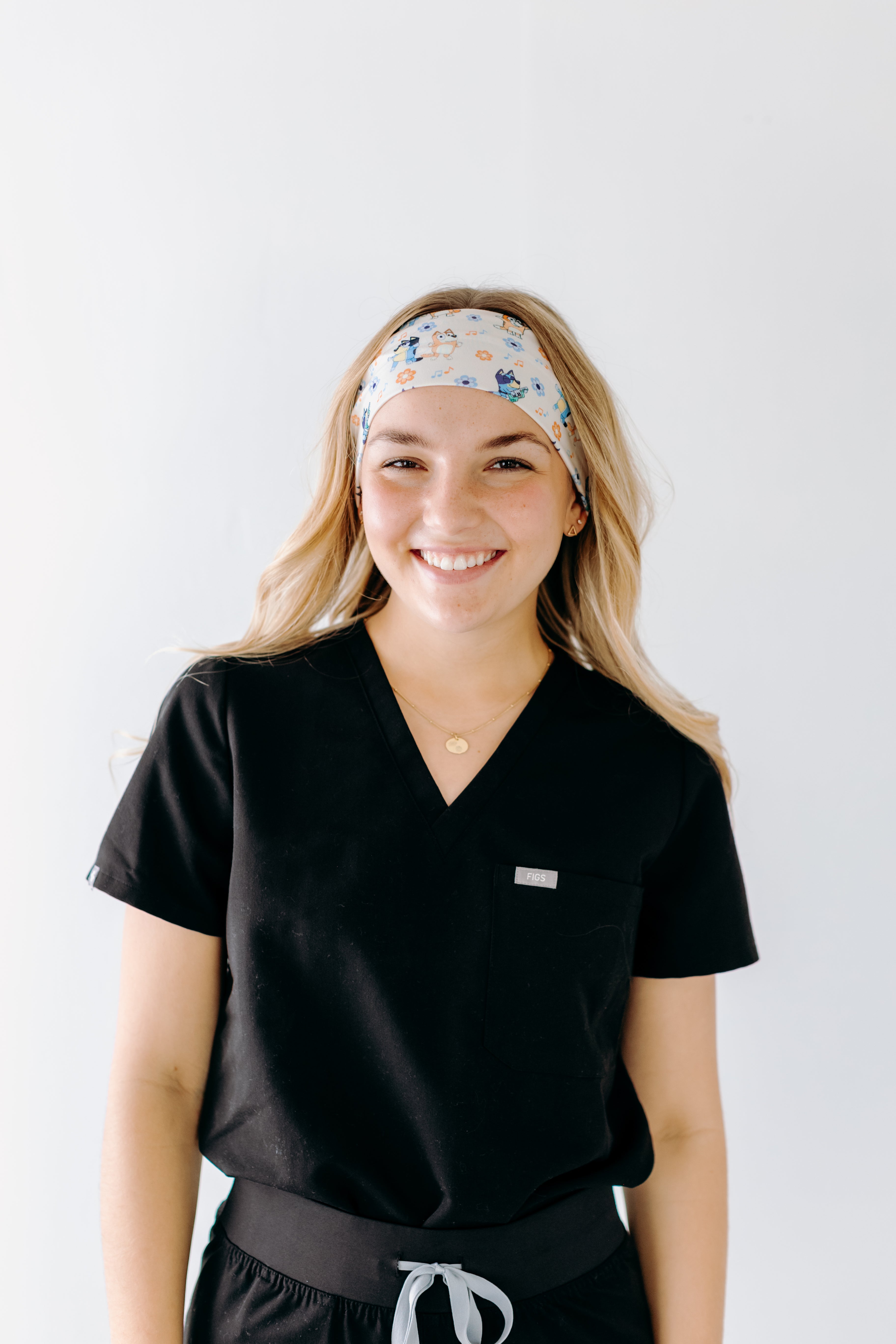 A nurse smiling with long hair while wearing theHeeler at Heart headband for cute hairstyles and comfortable all-day wear.