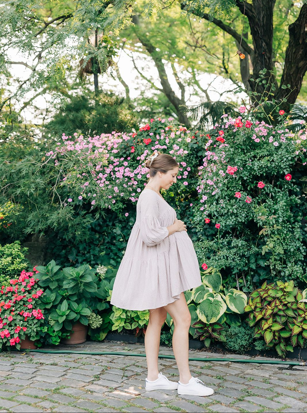 Woman wearing the Grow With Grace Clip from The Sarah Wallace collection, a 4.4-inch metal hair accessory with a flower design, securing her hair in a bun.