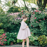 Woman wearing the Grow With Grace Clip from The Sarah Wallace collection, a 4.4-inch metal hair accessory with a flower design, securing her hair in a bun.