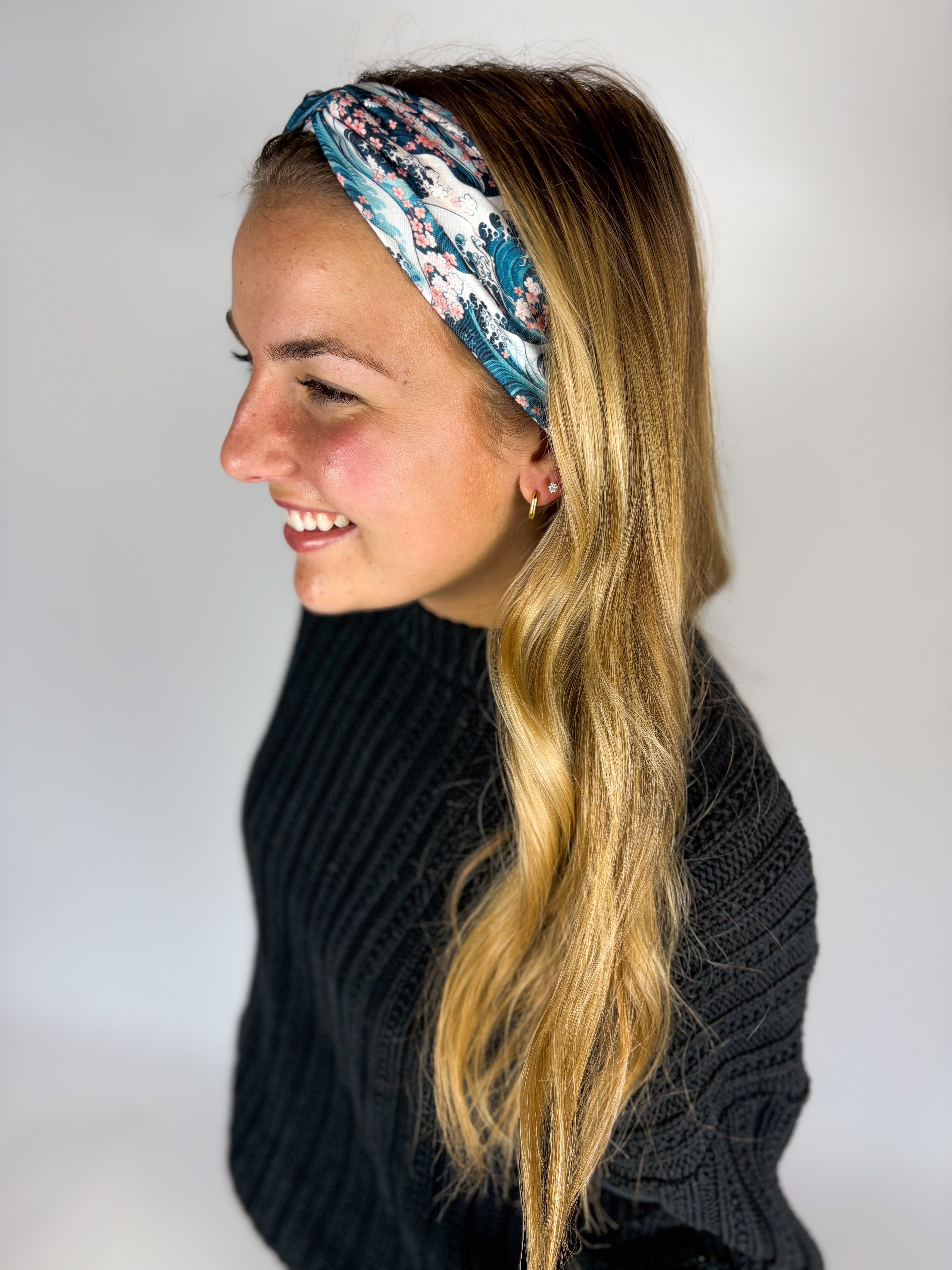 Woman wearing The Great Wave headband, showcasing its versatile 3-in-1 twist style and buttery-soft, non-slip fabric, ideal for work or play.