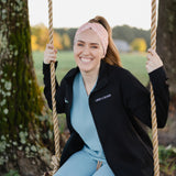 Woman in scrubs on a swing wearing a Nurse headband, showcasing its versatile, non-slip design, perfect for workouts or long shifts.