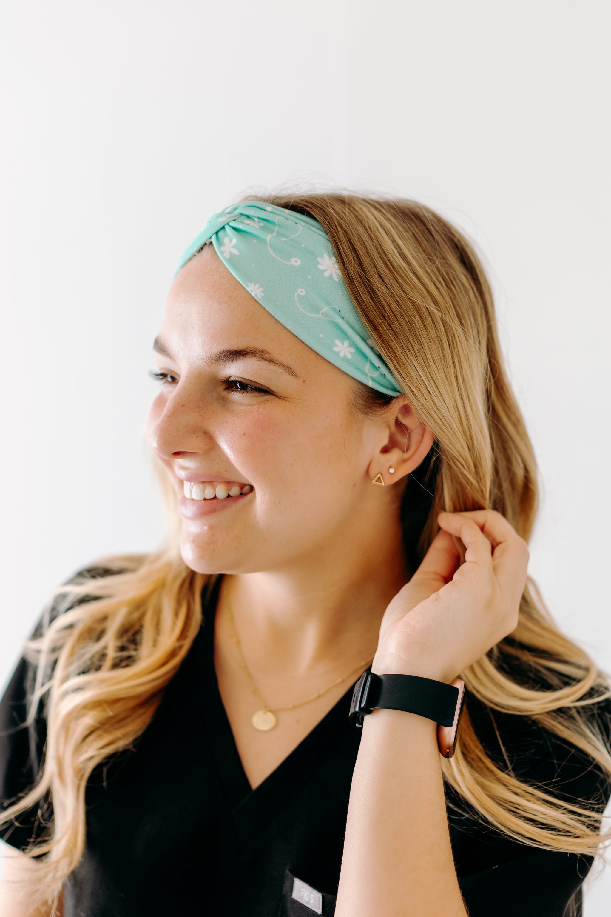 A nurse smiling with long hair while wearing the Undiagnosed But We're Pretty Sure headband for cute hairstyles and comfortable all-day wear.