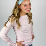 Woman wearing the Lost in Space headband, showcasing its versatile 3-in-1 twist style and buttery-soft, non-slip fabric, ideal for work or play.
