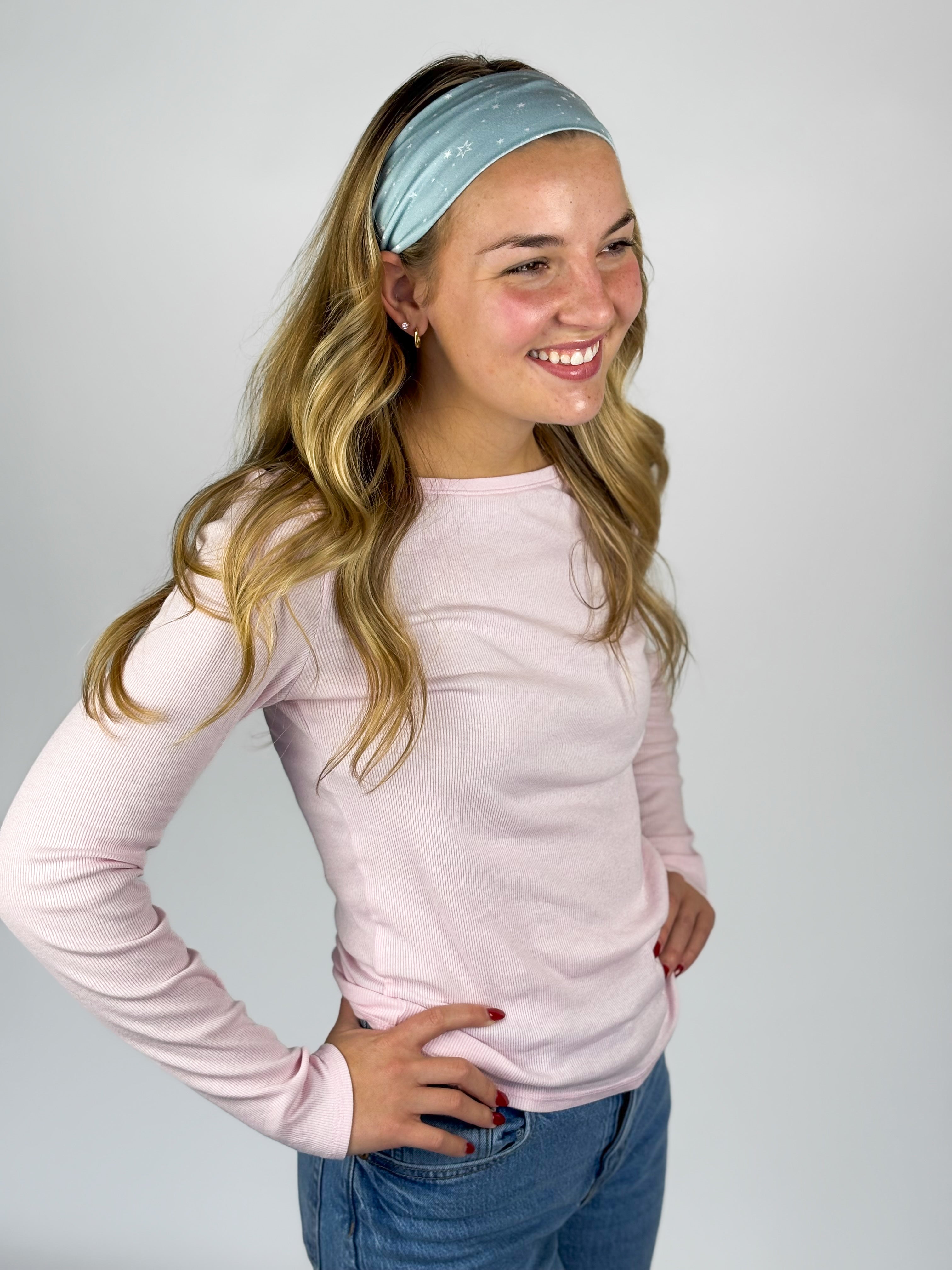 Woman wearing the Lost in Space headband, showcasing its versatile 3-in-1 twist style and buttery-soft, non-slip fabric, ideal for work or play.
