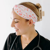A nurse smiling with hair pinned up while wearing the I'm Just Here For The Free Gloves headband for cute hairstyles and comfortable all-day wear.