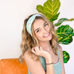 A woman confidently wearing the Don't Worry, Be Hoppy mint green headband with rabbits and flowers. An accessory for style and function, whether work or play.