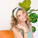 A woman confidently wearing the Don't Worry, Be Hoppy mint green headband with rabbits and flowers. An accessory for style and function, whether work or play.