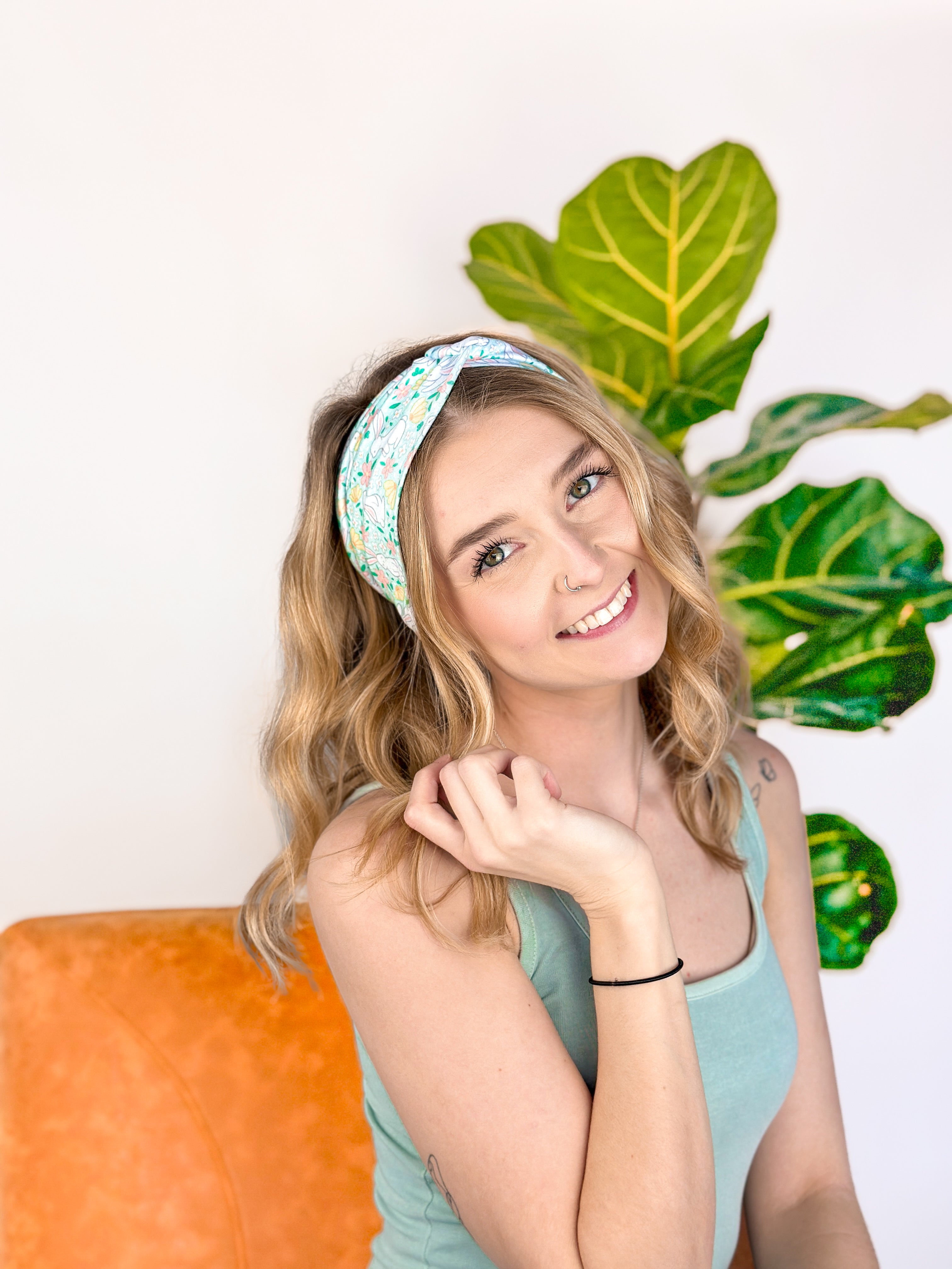 A woman confidently wearing the Don't Worry, Be Hoppy mint green headband with rabbits and flowers. An accessory for style and function, whether work or play.