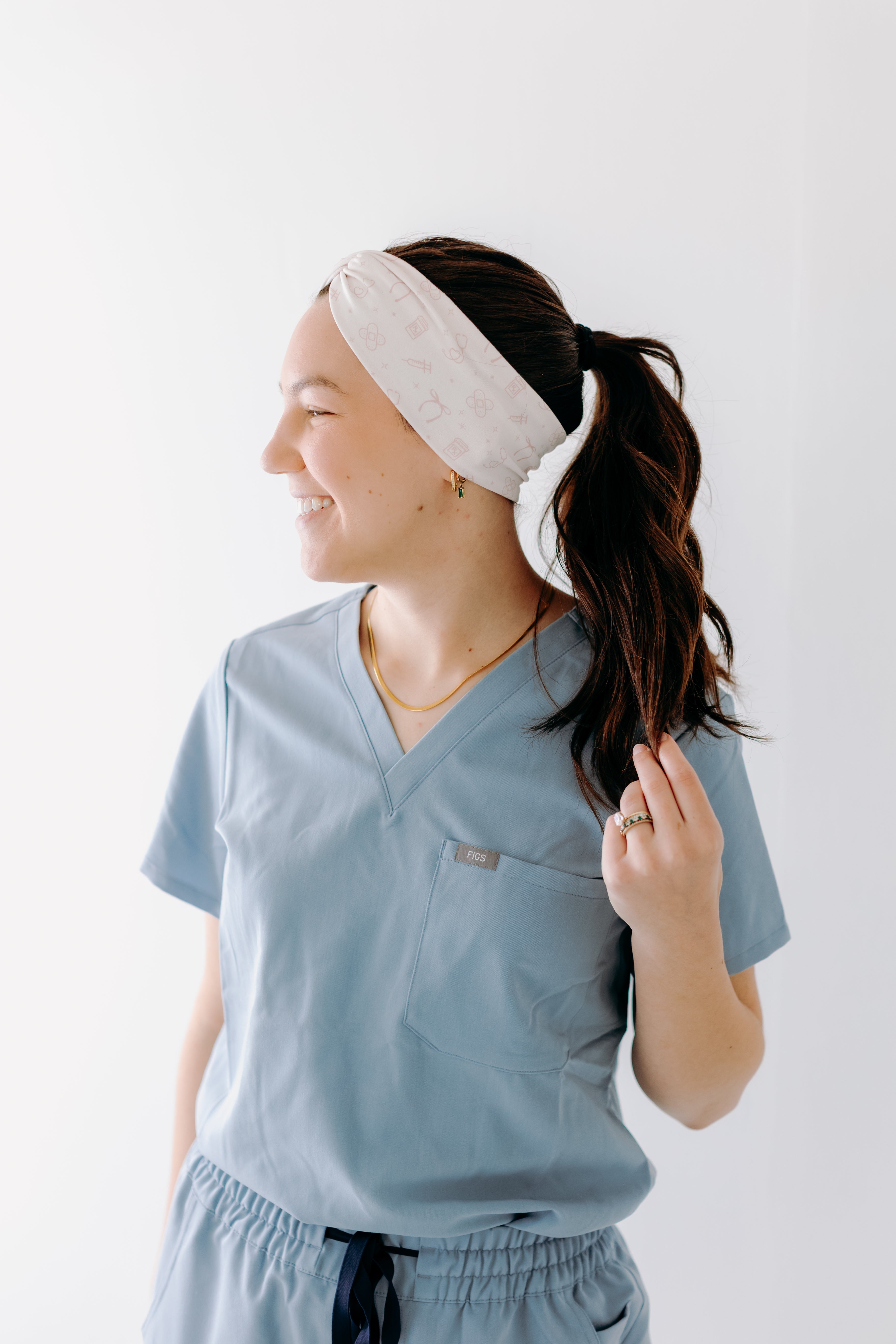 A nurse smiling with a long ponytail while wearing the Here to Save Your Butt for cute hairstyles and comfortable all-day wear.