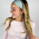 Woman wearing the Lost in Space headband, showcasing its versatile 3-in-1 twist style and buttery-soft, non-slip fabric, ideal for work or play.