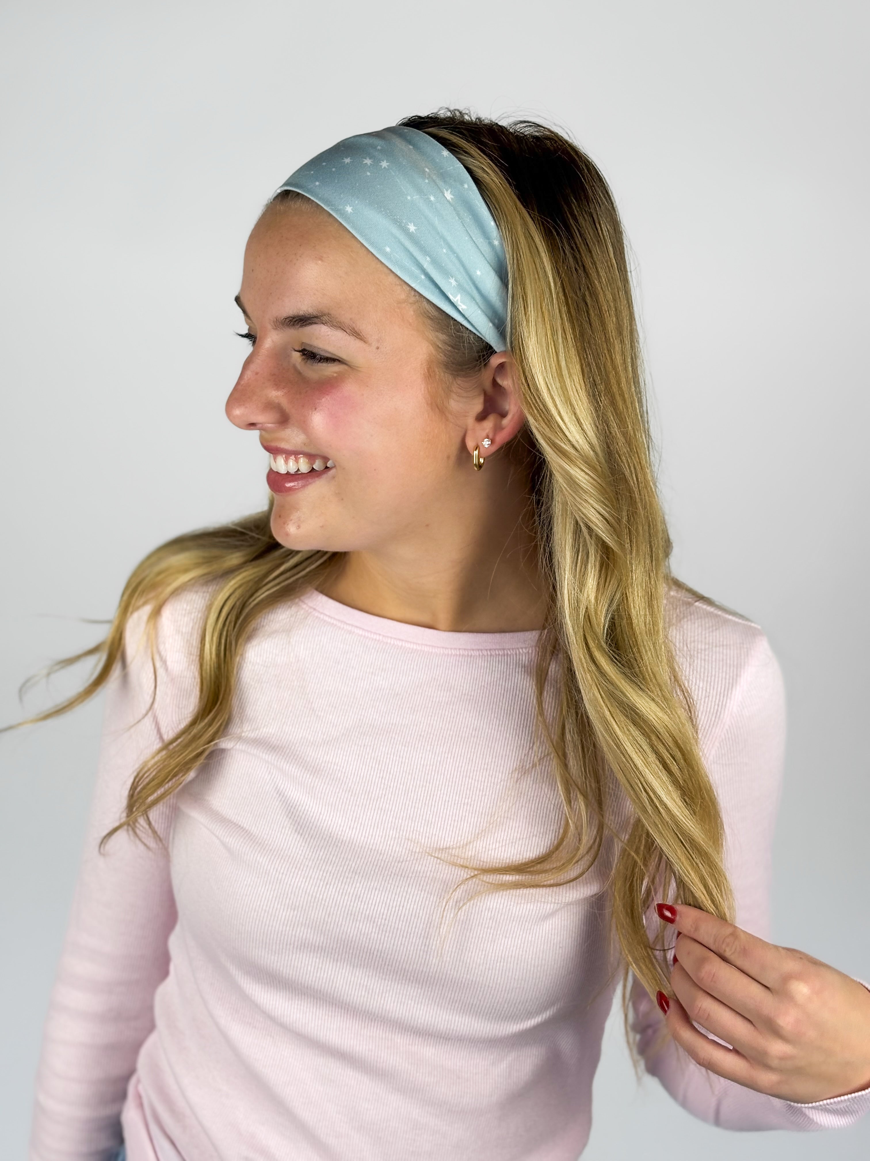 Woman wearing the Lost in Space headband, showcasing its versatile 3-in-1 twist style and buttery-soft, non-slip fabric, ideal for work or play.