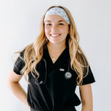 A nurse smiling with long hair while wearing the Nurses Do It Better headband for cute hairstyles and comfortable all-day wear.