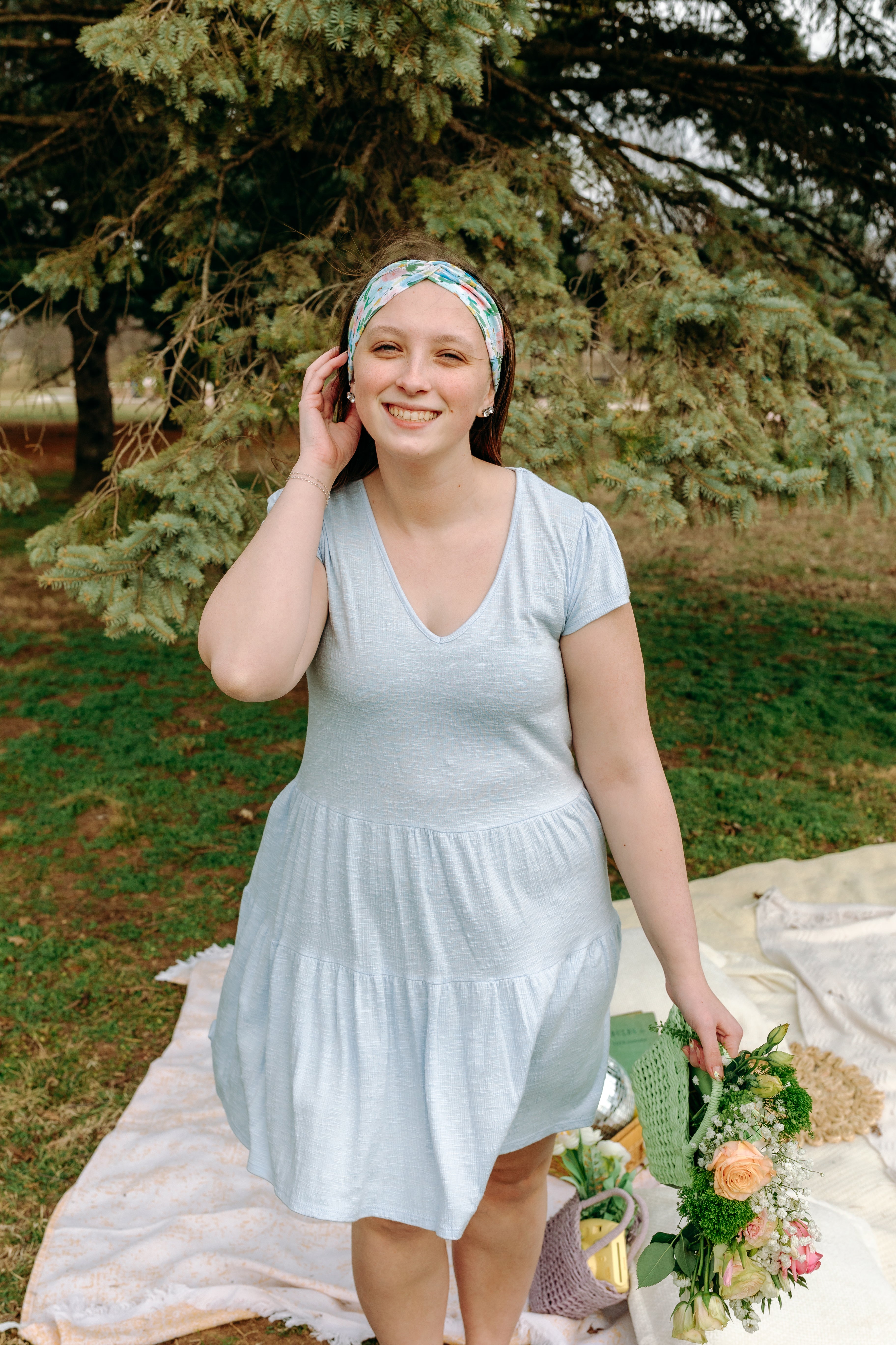 Woman smiling while wearing the Hope Floral on Ivory headband, the perfect non-slip accessory for work or workouts.