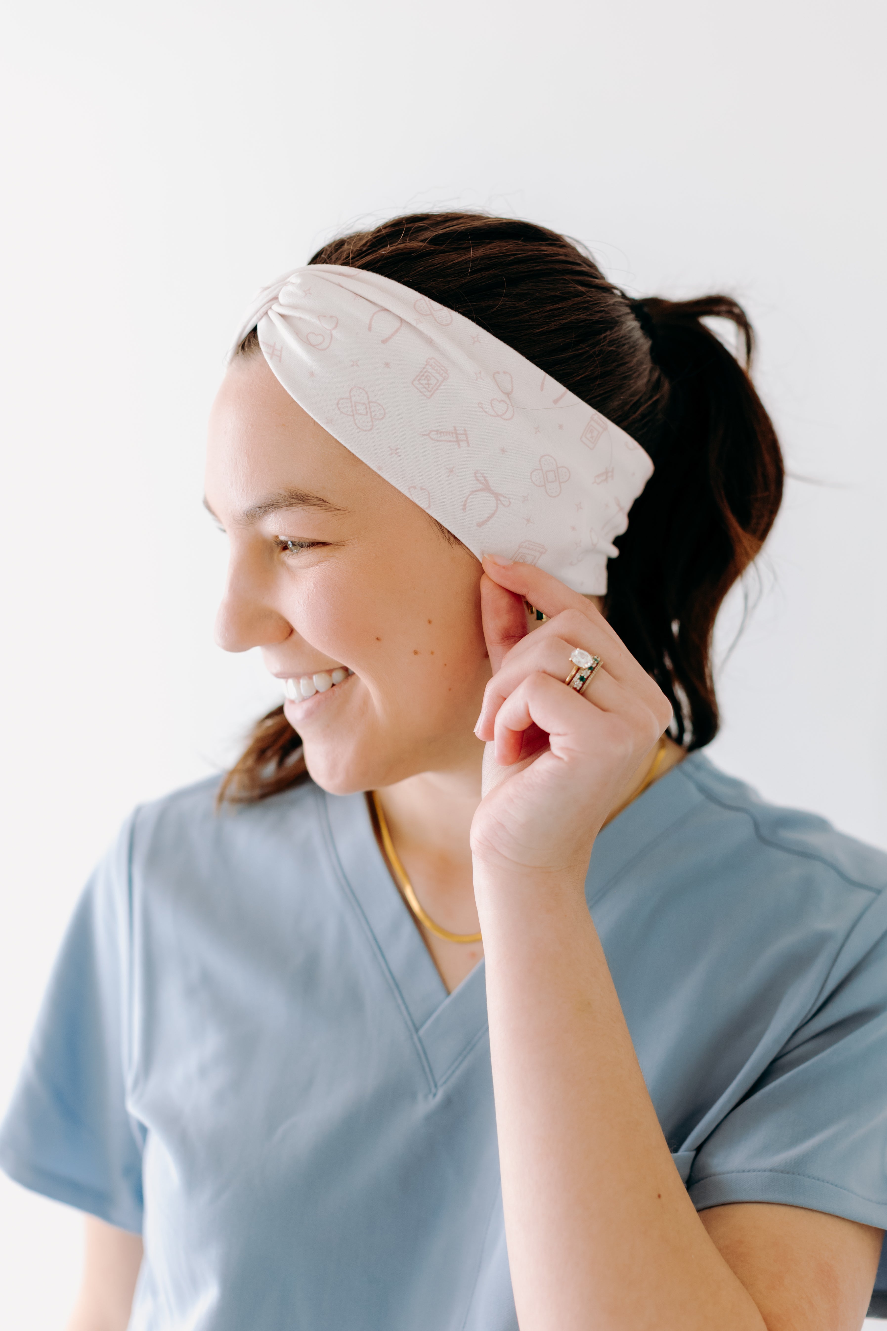 A nurse smiling with a long ponytail while wearing the Here to Save Your Butt for cute hairstyles and comfortable all-day wear.