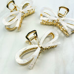 Treat Yourself Lilac Clip, a glossy 4-inch claw clip with hinge closure, available in two color options of white or black, perfect for keeping hair in place.