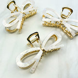 Treat Yourself Lilac Clip, a glossy 4-inch claw clip with hinge closure, available in two color options of white or black, perfect for keeping hair in place.