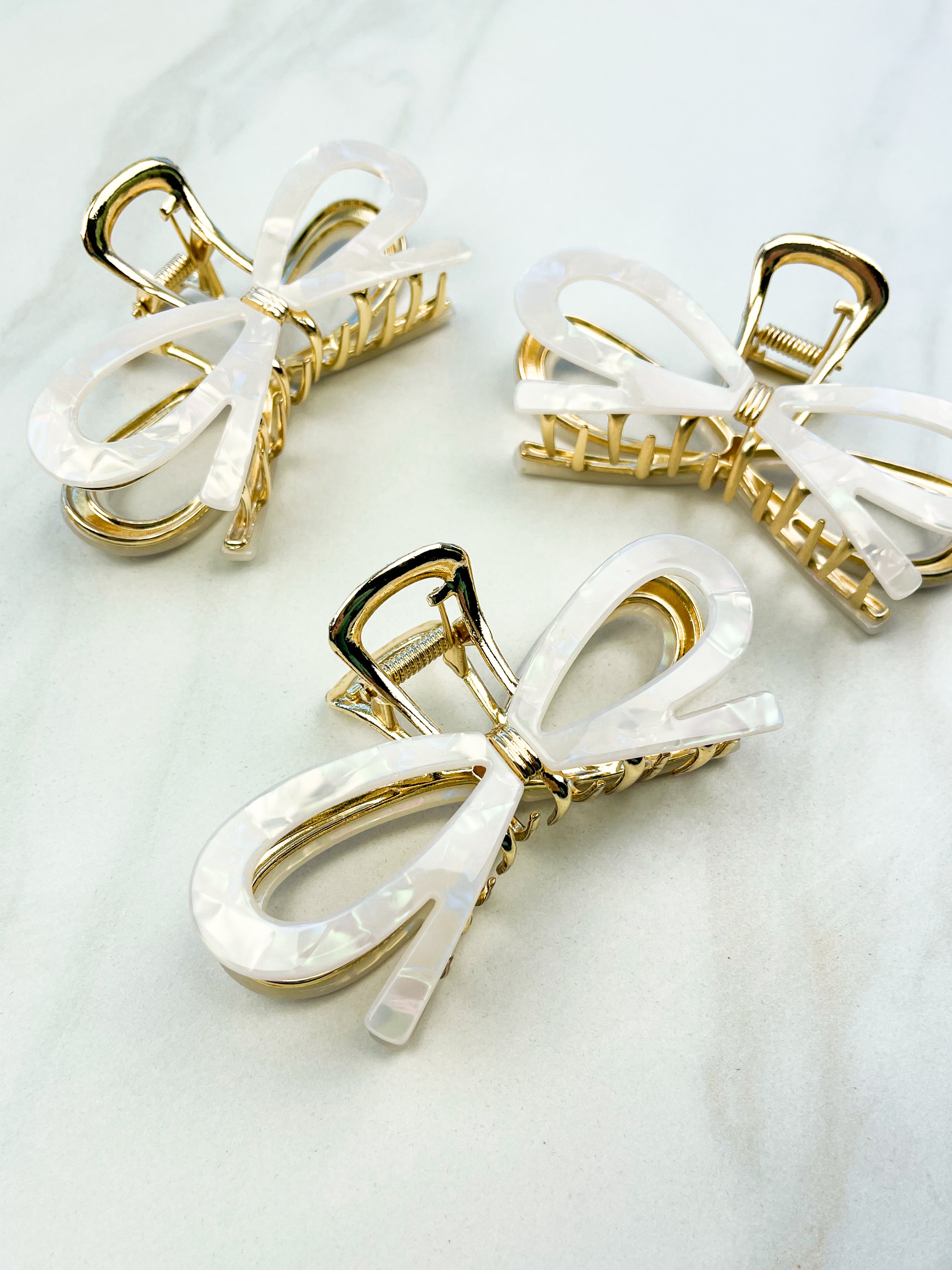 Treat Yourself Lilac Clip, a glossy 4-inch claw clip with hinge closure, available in two color options of white or black, perfect for keeping hair in place.