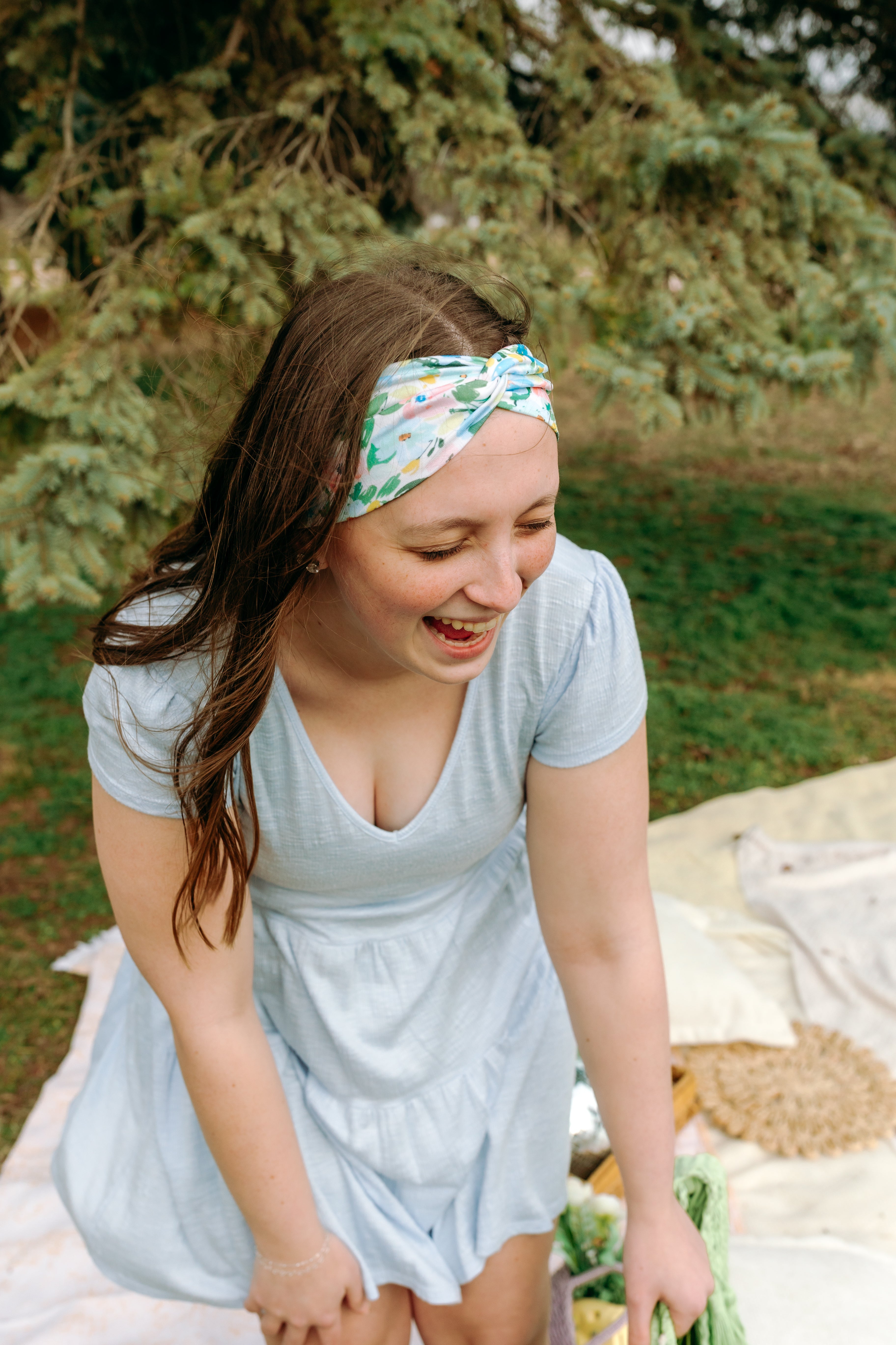 Woman smiling while wearing the Hope Floral on Ivory headband, the perfect non-slip accessory for work or workouts.