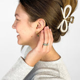 Woman confidently wearing the Treat Yourself Lilac Clip in her hair, featuring a 4-inch glossy metal claw design with hinge closure, styled in a twist.