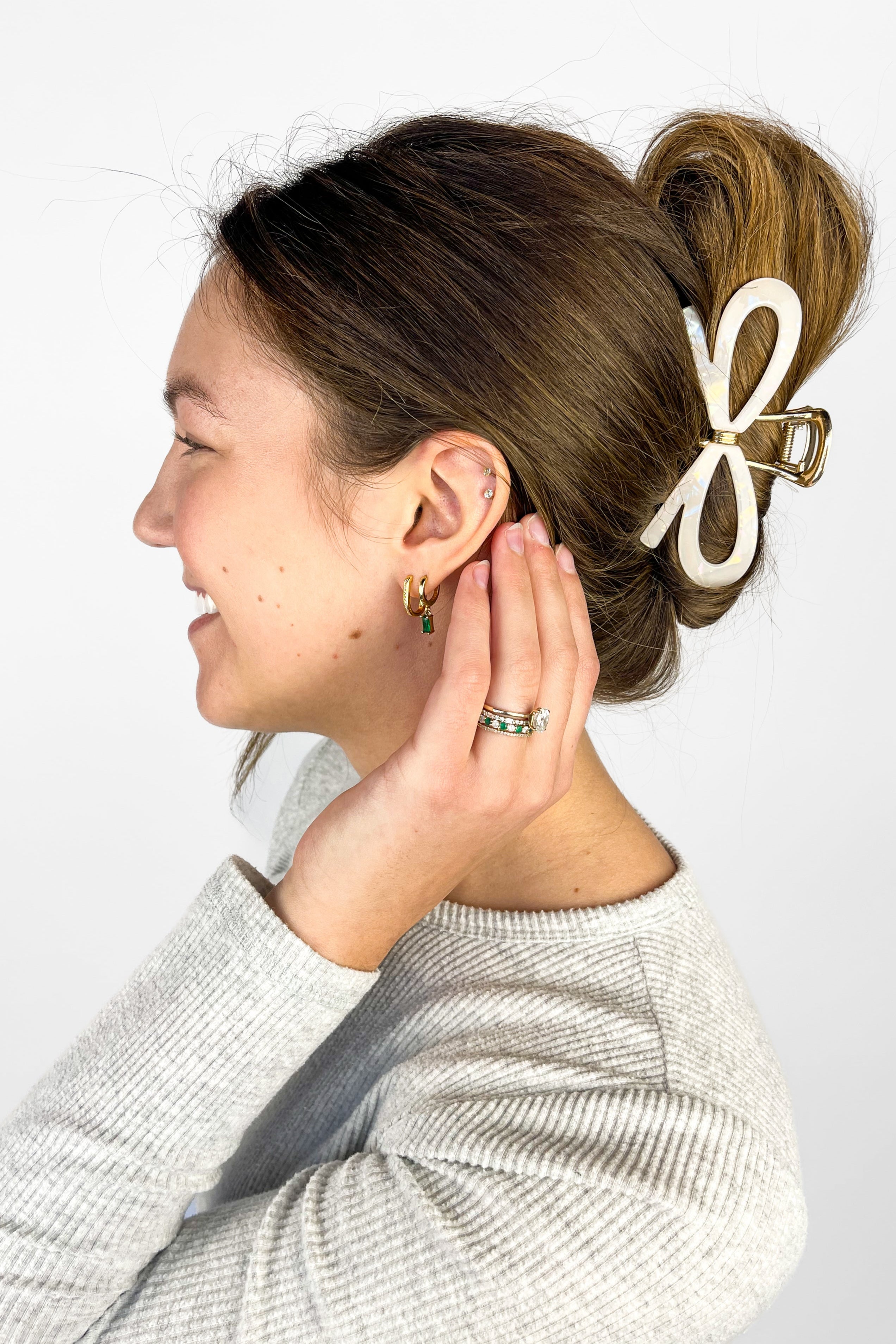 Woman confidently wearing the Treat Yourself Lilac Clip in her hair, featuring a 4-inch glossy metal claw design with hinge closure, styled in a twist.