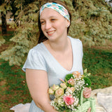 Woman smiling while wearing the Hope Floral on Ivory headband, the perfect non-slip accessory for work or workouts.