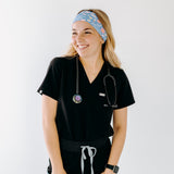 A nurse smiling with long hair while wearing the Born to Yap Forced to Chart headband for cute hairstyles and comfortable all-day wear.