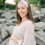 Woman smiling, wearing a Fortitude headband, showcasing its functional, versatile design. The headband is non-slip, sweat-absorbent, and perfect for workouts or daily wear.
