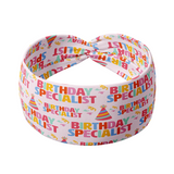 Birthday Specialist headband with confetti and birthday hats on pink fabric.