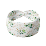 A Springtime in Brooklyn headband, featuring a white headband with green leaf pattern, versatile 3-in-1 twist style, and ultra-stretchy poly-knit blend.
