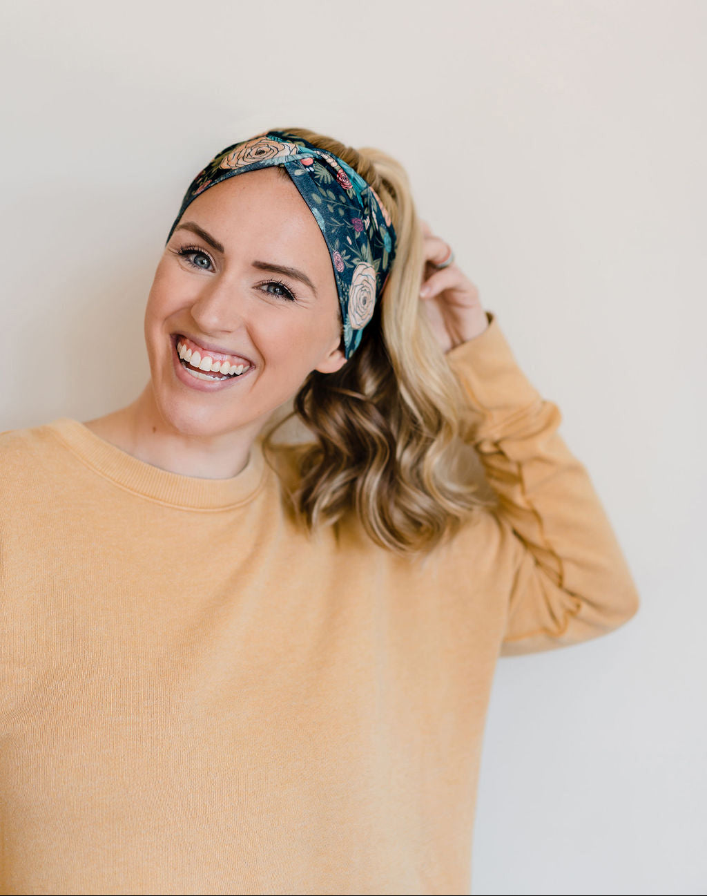 Adult women's black headband with hand-drawn gold, teal and coral roses with green stems and leaves