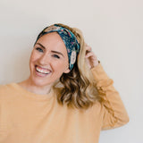 Adult women's black headband with hand-drawn gold, teal and coral roses with green stems and leaves