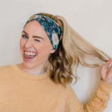 Adult women's black headband with hand-drawn gold, teal and coral roses with green stems and leaves