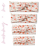 A group of white twist knot headbands for you and your mini me, featuring a pink and red butterfly and flower design, with adjustable fit for toddlers and babies.