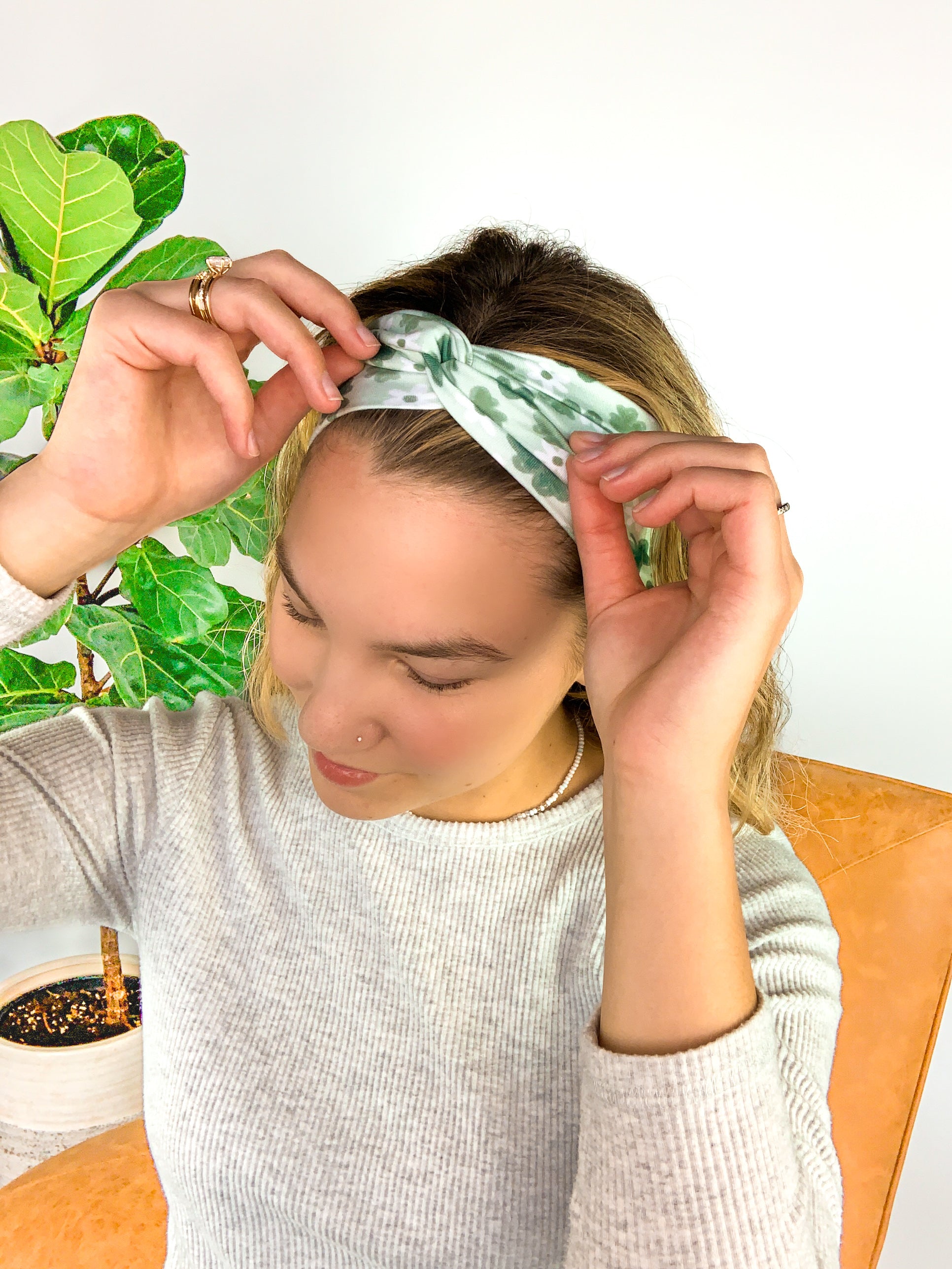 A woman wearing a Pinch Proof Lilac Market Headband, showcasing its functional and stylish design for confident wear during various activities.