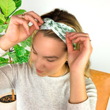 A woman wearing a Pinch Proof Lilac Market Headband, showcasing its functional and stylish design for confident wear during various activities.