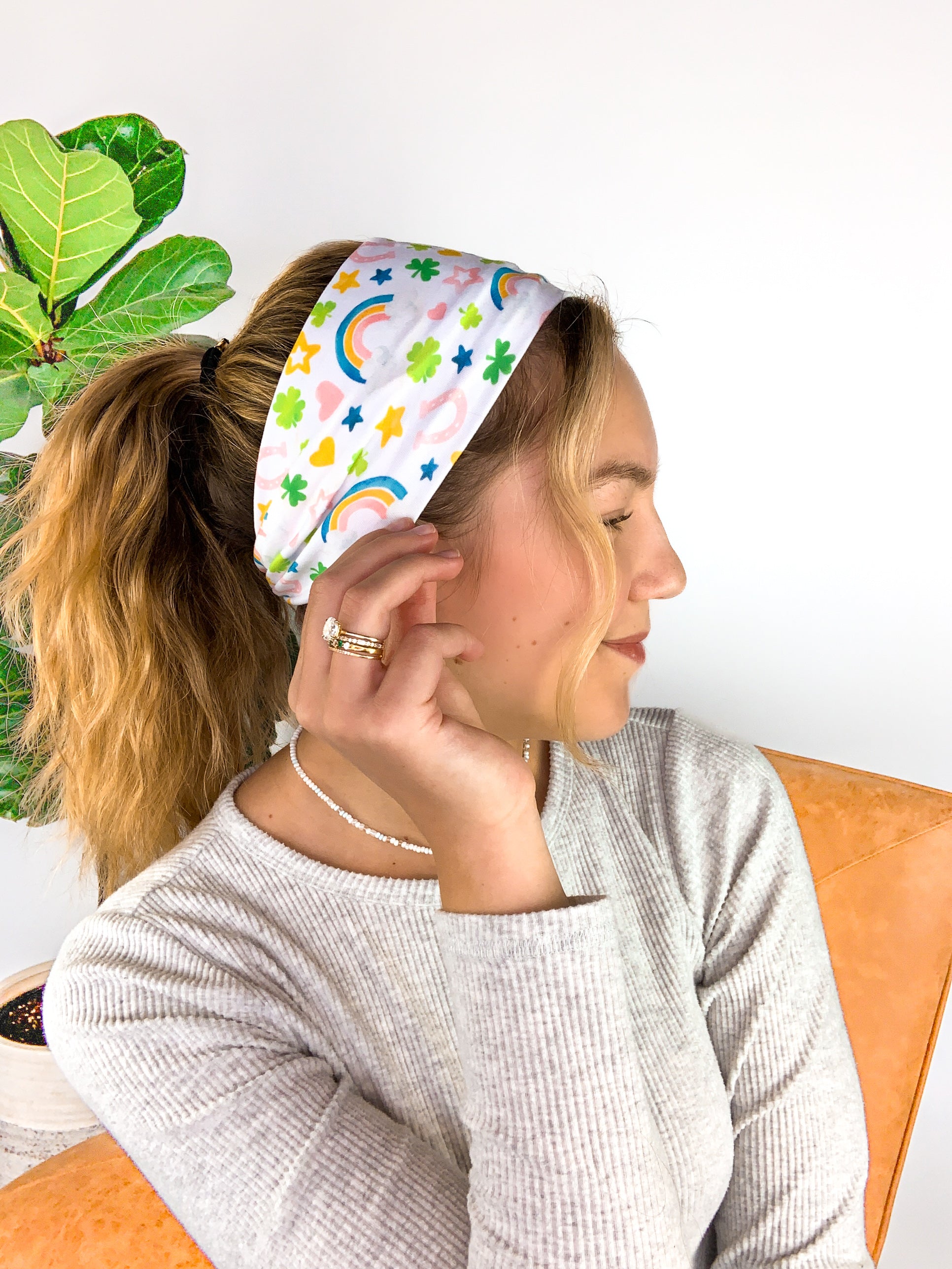 A woman wearing a You're My Lucky Charm headband, showcasing its functional and versatile design for confidence in any activity.