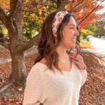 Woman smiling outdoors wearing It's Giving Thanks headband, showcasing its versatile 3-in-1 twist style and non-slip design against a tree backdrop.