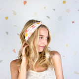 Woman smiling, wearing Field Trip to the Stars headband; ultra-stretchy, versatile, double-layered, non-slip, and sweat-absorbent. Ideal for workouts, long shifts, or playdays.