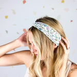 Woman smiling, wearing the Avonlea headband. The headband is a versatile, ultra-stretchy poly-knit blend, providing multiple ways to wear for various activities.