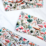 An Enchanted Garden headband with a mushroom and plant pattern, featuring a knot design. Versatile 3-in-1 twist style, sweat-absorbent, non-slip, and machine washable. Functional and stylish for any activity.