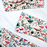An Enchanted Garden headband with a mushroom and plant pattern, featuring a knot design. Versatile 3-in-1 twist style, sweat-absorbent, non-slip, and machine washable. Functional and stylish for any activity.