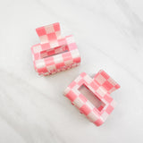 Checking In Lilac Clip: a 2-inch glossy peach checkered claw clip with a hinge closure, perfect for styling and keeping hair in place.