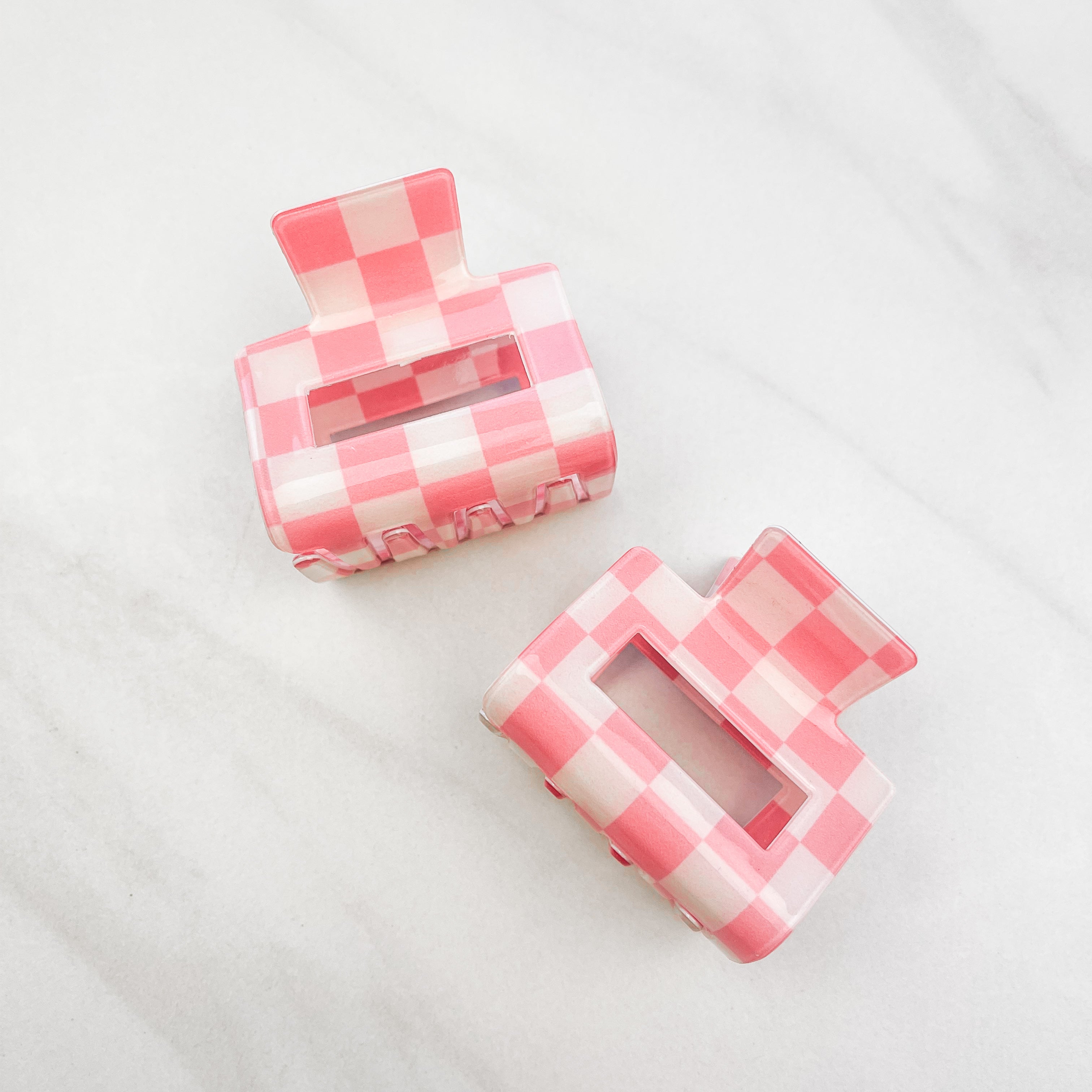 Checking In Lilac Clip: a 2-inch glossy peach checkered claw clip with a hinge closure, perfect for styling and keeping hair in place.