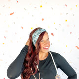 A woman confidently wears the Scrub In headband with a stethoscope, showcasing its versatile 3-in-1 twist style. Designed for function and style, perfect for workouts or workdays.