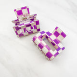 Checking In Lilac Clip: a 2-inch glossy purple checkered claw clip with a hinge closure, perfect for styling and keeping hair in place.