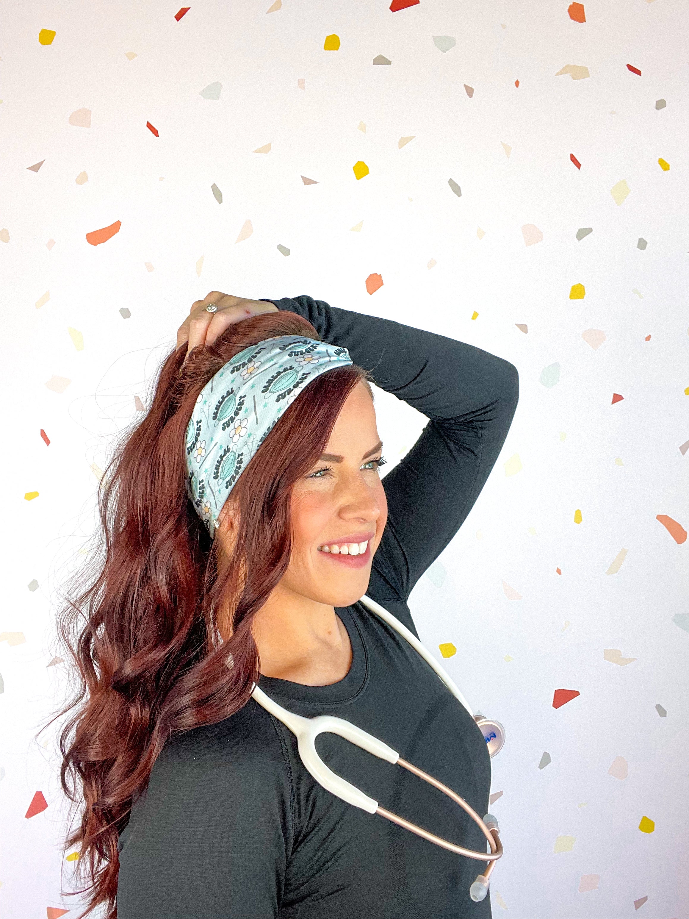 A woman confidently wears the Scrub In headband with a stethoscope, showcasing its versatile 3-in-1 twist style. Designed for function and style, perfect for workouts or workdays.