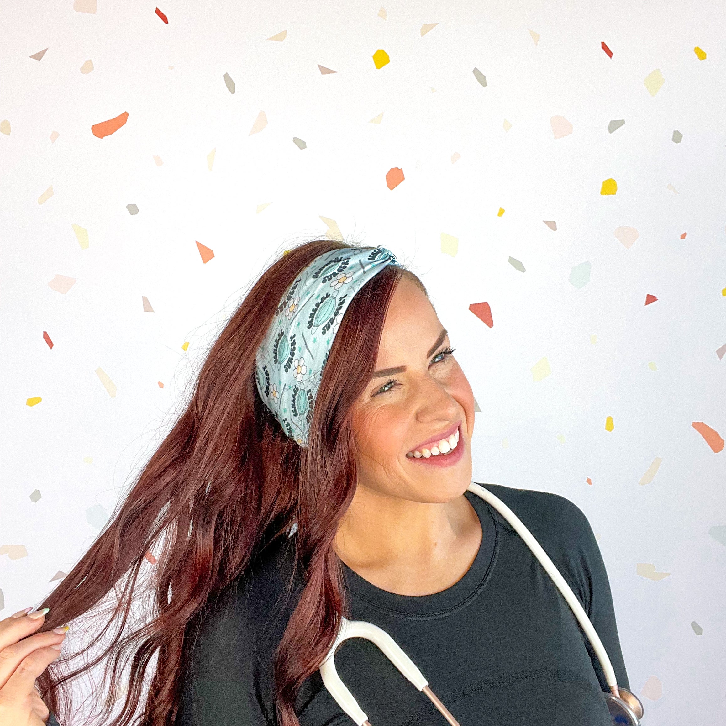 A woman confidently wears the Scrub In headband with a stethoscope, showcasing its versatile 3-in-1 twist style. Designed for function and style, perfect for workouts or workdays.