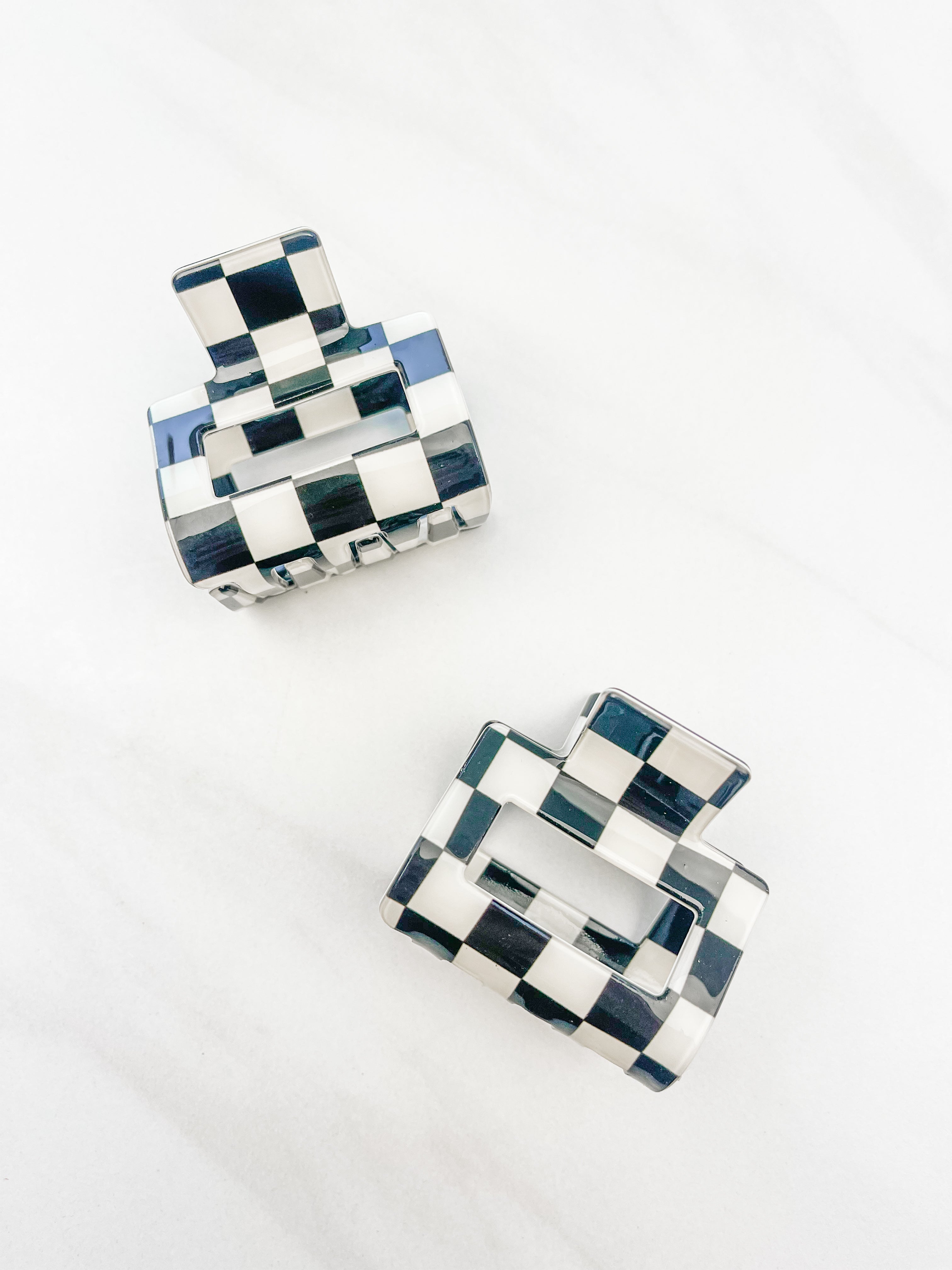 Checking In Lilac Clip: a 2-inch glossy black checkered claw clip with a hinge closure, perfect for styling and keeping hair in place.