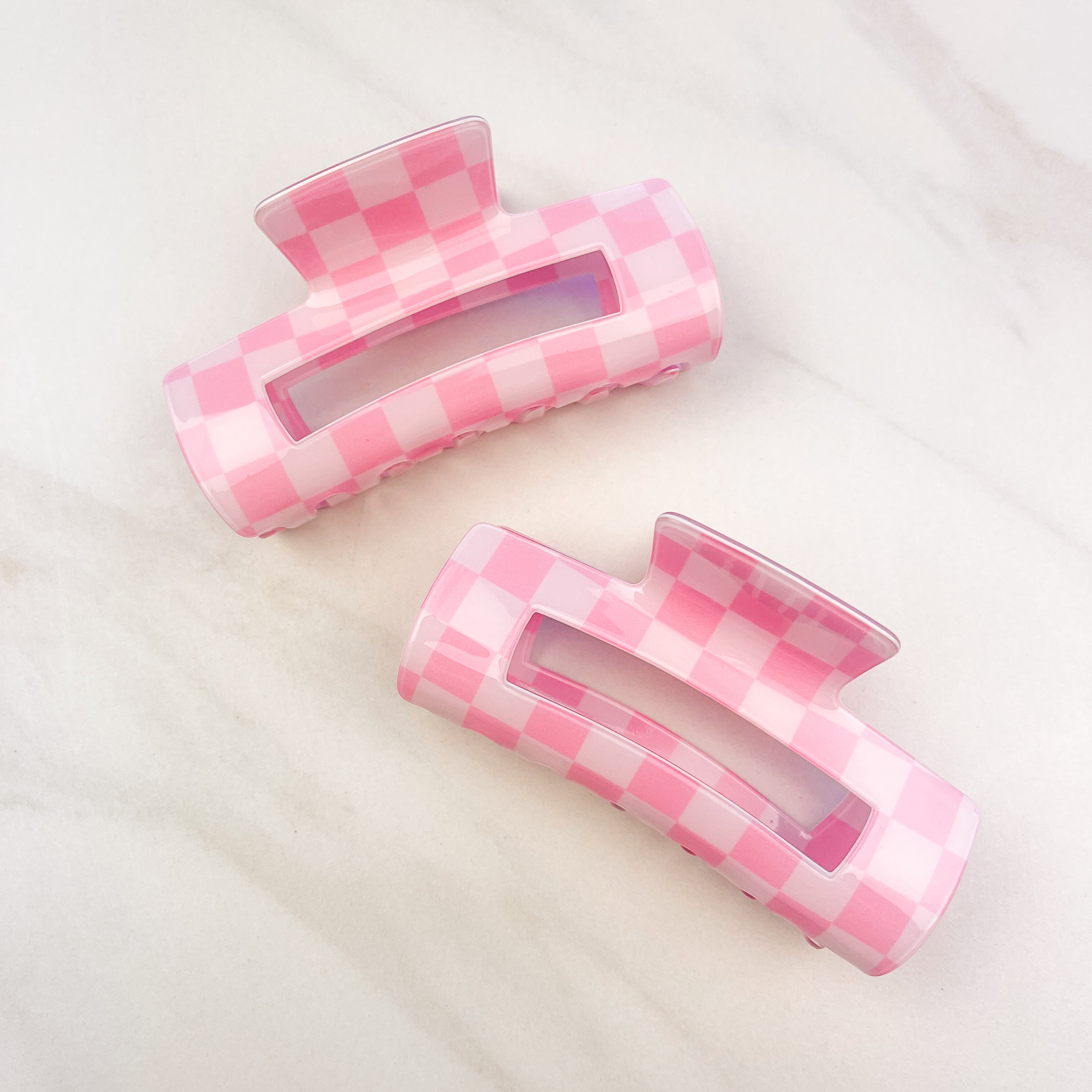 Checkmate Lilac Clip: a 3.6-inch glossy pink checkered claw clip with a hinge closure, perfect for styling and keeping hair in place.