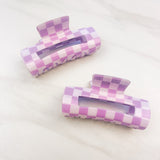 Checkmate Lilac Clip: a 3.6-inch glossy purple checkered claw clip with a hinge closure, perfect for styling and keeping hair in place.